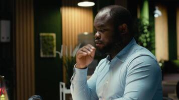 förbittrad svart kille i spänning få arg på grund av till intensiv arbetsbelastning, arbetssätt efter timmar i frustration och obehag. angelägen rastlös anställd varelse överväldigad i mörk kontor. kamera b. video