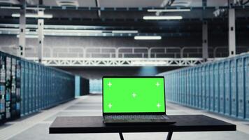 Isolated screen laptop in data center used for doing maintenance on infrastructure, improving workload. Chroma key notebook in server farm used by high tech server clusters for parallel processing video