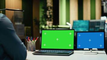 ung svart konsult ser på blå och grön skärm på enheter, sent natt arbete session efterbehandling fast administrering uppgifter efter timmar. använder sig av isolerat visa på bärbar dator och läsplatta. kamera b. video