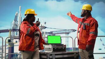 isoliert Bildschirm Laptop benutzt durch Bohren rig Besatzung Kollegen halten Radio Gerät zu Monitor Systeme. Ingenieurwesen Mannschaft auf Off-Shore Plattform Deck mit Walkie Talkie und Chroma Schlüssel Notizbuch, Kamera ein video