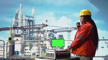 isolerat skärm läsplatta Begagnade förbi borrning rigg expert- till övervaka system, talande i handhållen radio. offshore plattform tekniker använder sig av walkie talkie, kalibrerar redskap med krom nyckel enhet, kamera en video