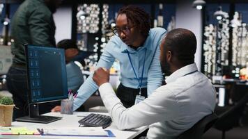 Due nero lavoratori interagendo con un' virtuale assistente su computer a scrivania, risposte e inteligente automazione per Ottimizzare in linea comunicazione. dati guidato ai soluzioni. telecamera b. video