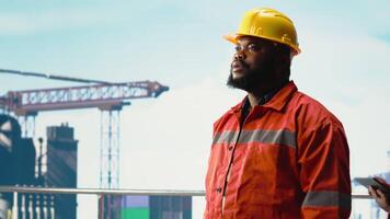 porträtt av Lycklig offshore plattform arbetstagare tala i walkie talkie, konfigurera borrtorn förvaltning system. leende borrning rigg arbetstagare håller på med havsbotten analys, talande i handhållen radio, kamera b video