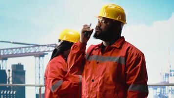 porträtt av Lycklig borrning pråm ingenjör använder sig av walkie prat möjliggör snabbt svar samordning nödvändig. glad man på olja plattform däck lyssnande till rapporter genom radio transceiver, kamera b video
