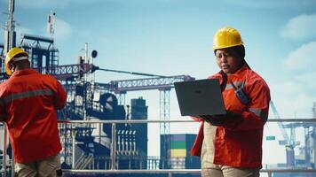 porträtt av leende offshore plattform ingenjör använder sig av övervakning app till Spår förorening data. Lycklig kvinna utför miljö- risk bedömning för borrning rigg webbplats använder sig av anteckningsbok, kamera en video
