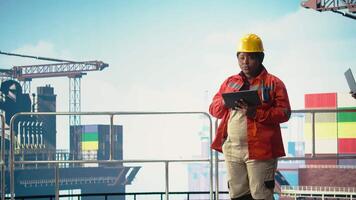 offshore plattform kollegor övervakning däck operationer med enheter, säkerställa överensstämmelse med säkerhet protokoll. team av tekniker håller på med Utrustning kolla upp på borrning rigg, kamera en video