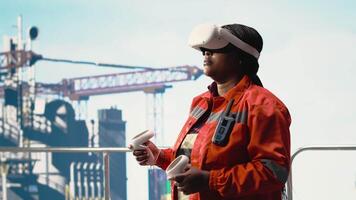 Drilling rig operator tracking oil production efficiency with VR goggles doing maintenance tasks. Offshore platform expert uses virtual reality technology to check equipment sensor readings, camera B video