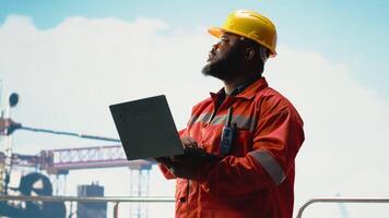 man arbetssätt på borrning rigg fartyg, genomförande skyddsåtgärder till minska hav förorening. miljö- skydd expert- övervakning offshore plattform kol fotavtryck använder sig av bärbar dator, kamera b video