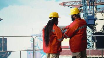 Bohren rig Boot Ingenieurwesen Mannschaft mit Laptop zu Monitor Ausrüstung Systeme. Off-Shore Plattform Teamarbeit Kollegen kalibrieren Ausrüstung mit Notizbuch Programm, tun Wartung, Kamera ein video