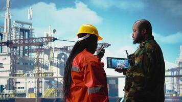 naval unidade em perfuração equipamento barcaça usando tábua para visualizar sistemas, salvaguardando a infraestrutura. exército soldado em no mar plataforma área coberta impede pirataria usando dispositivo para faço segurança plano, Câmera uma video