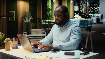 oberati di lavoro maschio lavoratore controllo calendario prima programmazione Fidanzamento, raccolta su il suo smartphone per risposta testi e leggere notifiche. persona ottenere distratto e accigliato. telecamera un. video