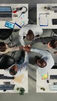 vertikal topp ner se av företag människor fira lagarbete med filer och diagram i samarbete kontor. arbete team justeras strategi och förvaltning med insikter för förbättrad prestanda. kamera a. video