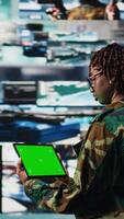 Vertical Isolated screen mockup tablet warning system used by military operator to monitor incoming enemy aerial attacks. Army agent maintains air space superiority with radar on chroma key device, camera A video