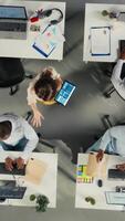 vertical topo baixa Visão ampliação dentro do colegas dentro multinacional companhia escritório discutir estratégia, gráficos e análise. trabalhos equipe coordenadas progresso, intuições e documentação para Melhor resultados. Câmera uma. video