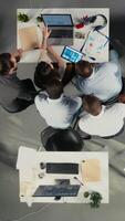 vertikal topp ner se av olika yrkesverksamma samarbetande på företag analys, granskning visuell data och framskrivningar till Stöd strategi och framsteg inom multinationell företag. kamera a. video