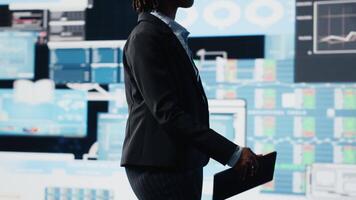 chef använder sig av läsplatta till jämföra företag metrik på digital videovägg innan framställning beslut. entreprenör analyserar nyckel prestanda indikatorer använder sig av enhet app till optimera lönsamhet, kamera b video