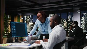 African american staff members use AI chatbot system at pc for problem solving tasks, futuristic high tech highlighting smart algorithms and deep learning. Communication and IT support. Camera A. video