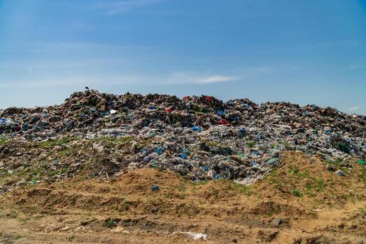 Large mound of waste dominates the landscape, showcasing the critical issue of pollution and the urgent need for better waste management practices photo