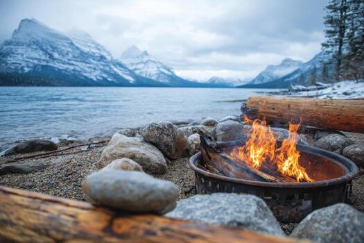 Campfire by the lake and a snowy mountain in the background photo