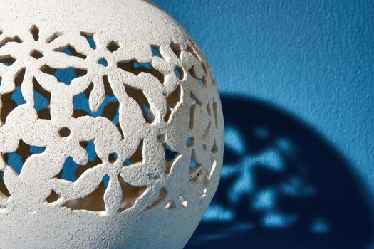 Decorative ceramic vase casting intricate shadows photo
