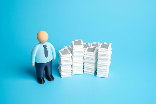 An office worker and stacks of documents and work papers. High bureaucratic burden and extensive paperwork for workers. Concept for administration overload, office routine photo