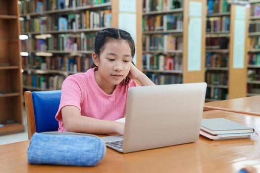 Student girl learning online class by using laptop computer and writing notebook at workplace, E learning and online working concept. photo