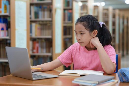 Student is learning online class by using laptop computer and writing notebook at workplace, E learning and online working concept. photo