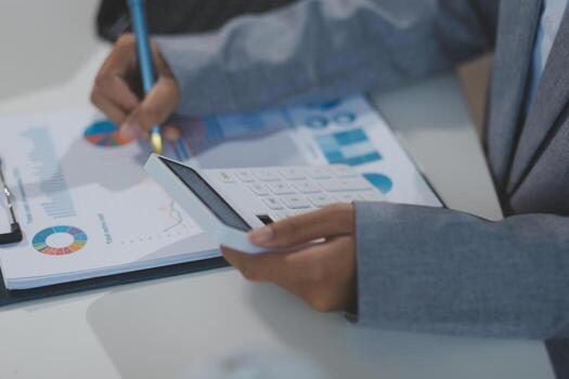 empresario utilizando calculadora y bolígrafo a calcular foto