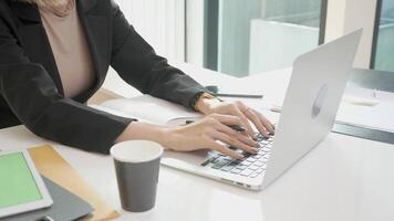 Nahansicht Hände von jung Frau Tippen Tastatur auf Laptop Computer im das Büro, Exekutive oder Manager mit Notizbuch zu Internet online, Mitarbeiter und Buchhaltung, Geschäft und Kommunikation Konzept. video
