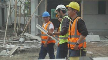 Group team engineer and architect with contractor walking and inspect about scheme building site for planning project to worker and looking blueprint, construction site, development and structure. video