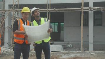 squadra gruppo di contraente e architetto con caposquadra spiegando di schema edificio luogo per pianificazione progetto per lavoratore e guardare planimetria, costruzione luogo, sviluppo e struttura. video