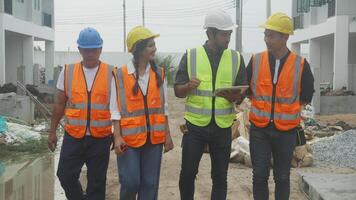 gruppo squadra architetto e costruttore a piedi e guardare digitale tavoletta computer per ispezionare progetto Residenziale a costruzione luogo, contraente e lavoratore discussione e pianificazione, ingegnere concetto. video