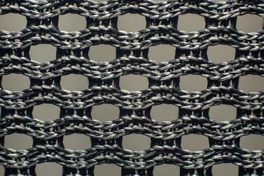 Macro closeup of black synthetic woven fabric mesh with braided threads and geometric grid pattern photo