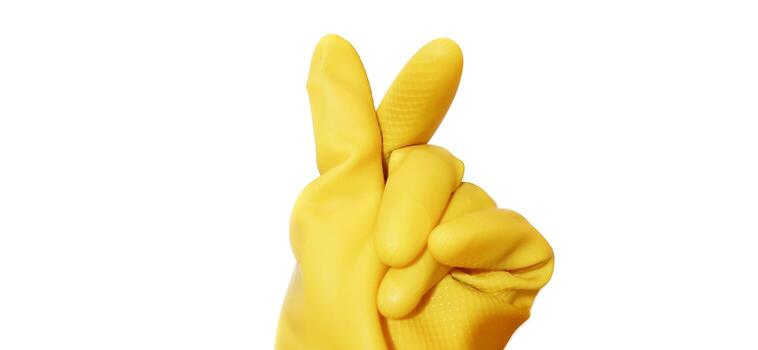 Hand gesture in yellow rubber glove showing finger mini heart isolated on a white background photo