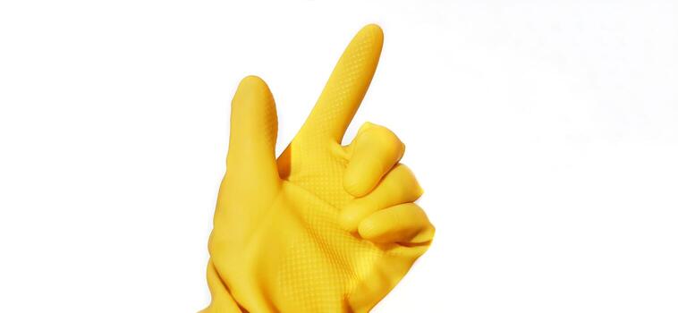 Hand gesture in yellow rubber glove showing index finger, pointing sign gesture isolated on a white background photo
