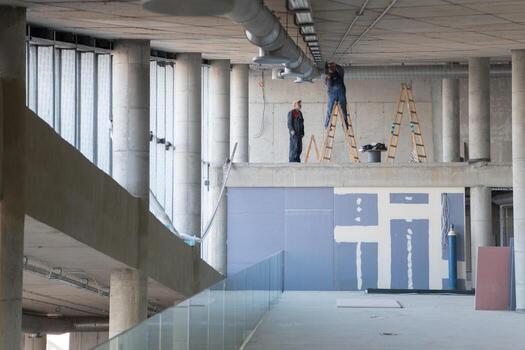 A team of workers collaborates to install a modern ventilation system within a building, carefully positioning ducts and ensuring efficient airflow for optimal performance photo