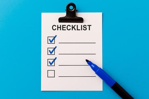 A checklist with three items checked off in blue marker. A blue marker is near the list. Task management photo