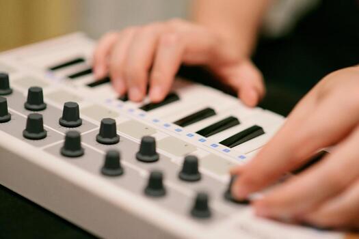 A Man Playing A Synthesizer Keyboard MIDI Controller. Hands close up. Electronic Music Production concept. photo