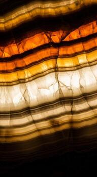 Close up of translucent banded agate illuminated from behind creating a warm glowing effect with natural earthy tones and intricate vein patterns photo
