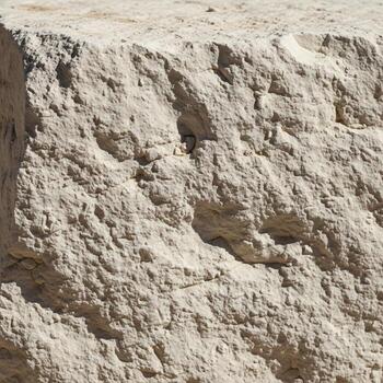 Close up view of a weathered and eroded cliff face showing layers of sediment and rough textured earth photo