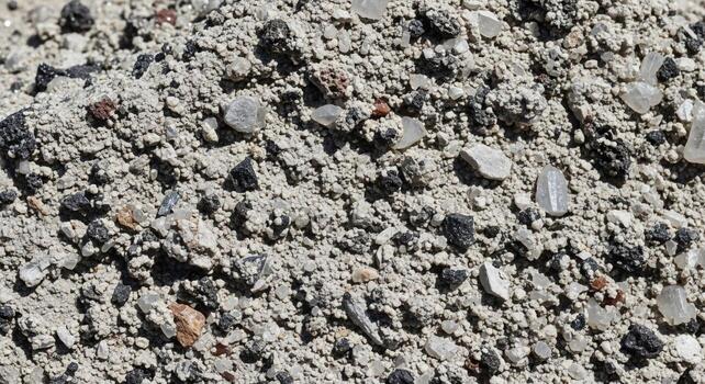 Close up view of a rough textured concrete surface with visible aggregate of various sizes and colors photo