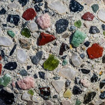 Close up of a textured concrete surface embedded with colorful glass shards and aggregate for a decorative finish photo
