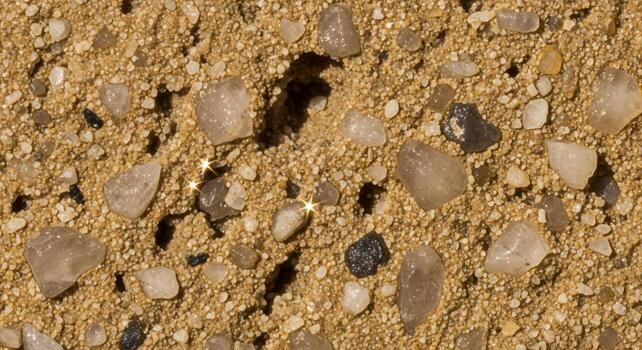 Close up view of rough textured desert soil with embedded pebbles and small stones creating a natural earthy pattern photo
