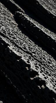 Close up textured abstract of dark weathered wood grain with deep shadows and highlights creating a dramatic moody effect photo