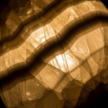 Close up view of translucent amber colored stone with layered textures and internal light reflections creating a warm glow photo