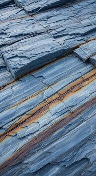 Close up view of weathered blue slate tiles with subtle streaks of rust and natural variations in texture and color photo