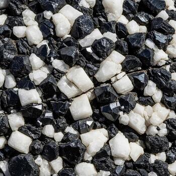 Close up view of a textured surface composed of small irregularly shaped black and white particles creating a visually interesting abstract pattern photo