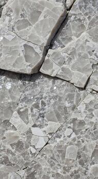 Close up abstract view of fractured gray rock surface with subtle green mineral inclusions and sharp angular fragments photo