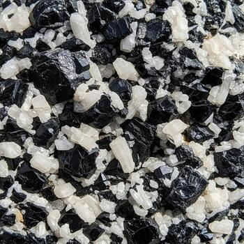 Close up abstract texture of dark and light granular material creating a speckled or mottled pattern photo