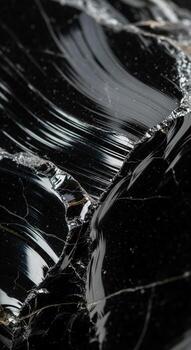 Close up abstract macro view of a fractured black obsidian rock with sharp edges and reflective surfaces photo